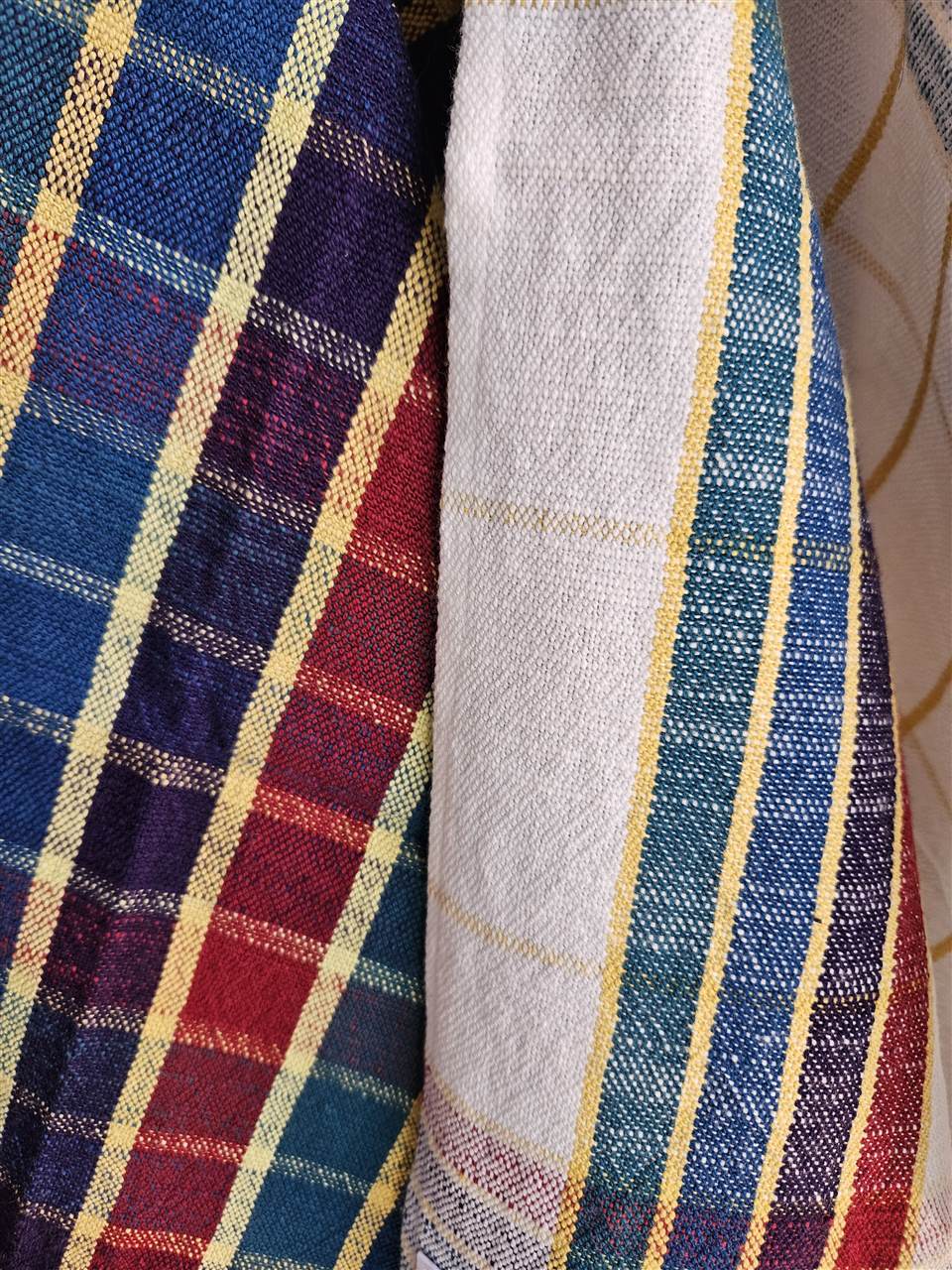 Detailaufnahme von bunten und weissen Tüchern mit gelben Streifen